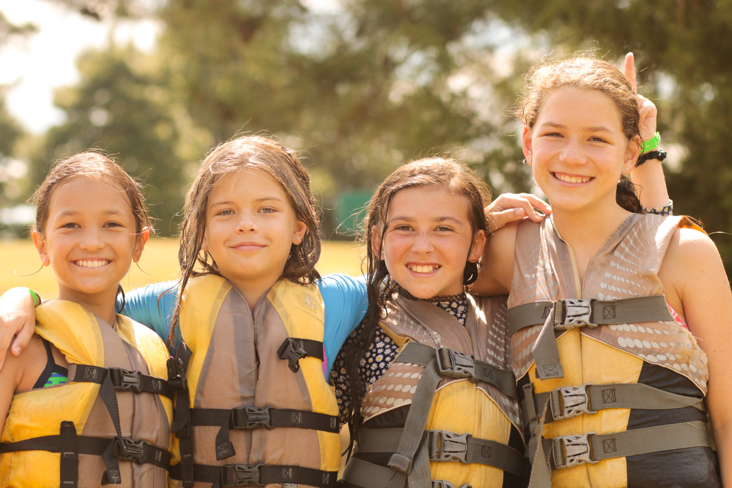 First-time campers in life jackets smiling together at the lake at YMCA Camp Weaver